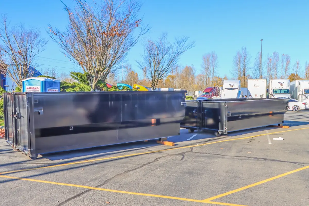 Professional dumpster rental service with roll-off container on residential driveway in Fort Dodge